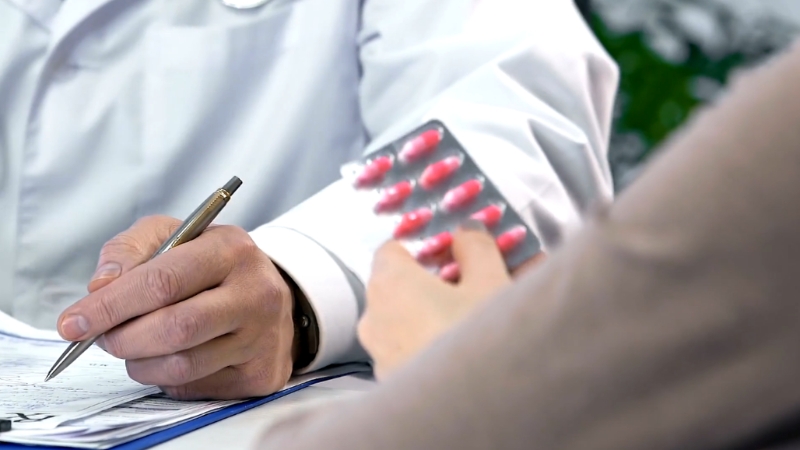 Pacijent drži terapiju dok lekar zapisuje nalaze tokom konsultacije